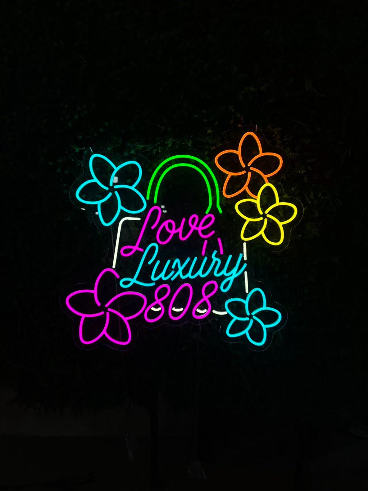 Meerkleurig neonbord met bloemen en de tekst Love Luxury 808